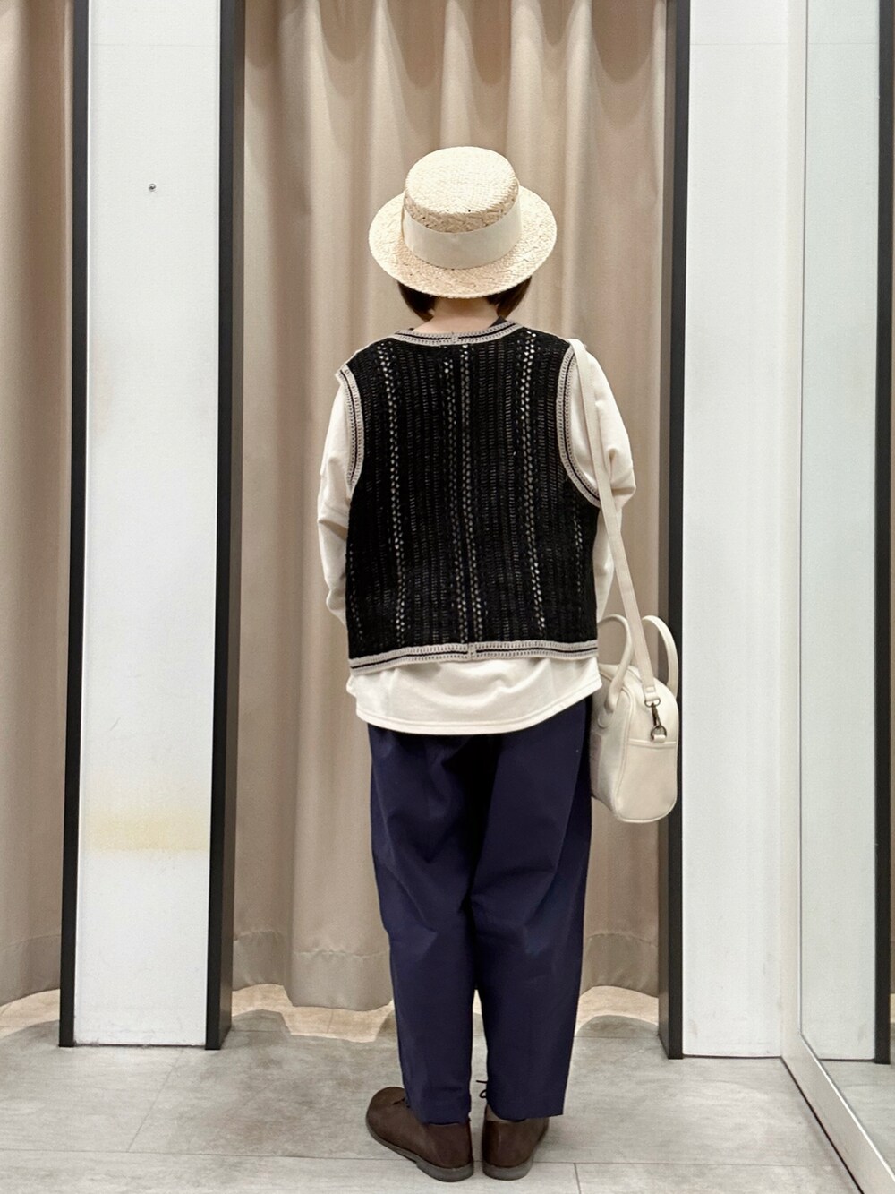 ブラック系のベスト、ブルー系のその他パンツ、ブラウン系のドレスシューズを着用したレディースの春コーディネートの3枚目の写真