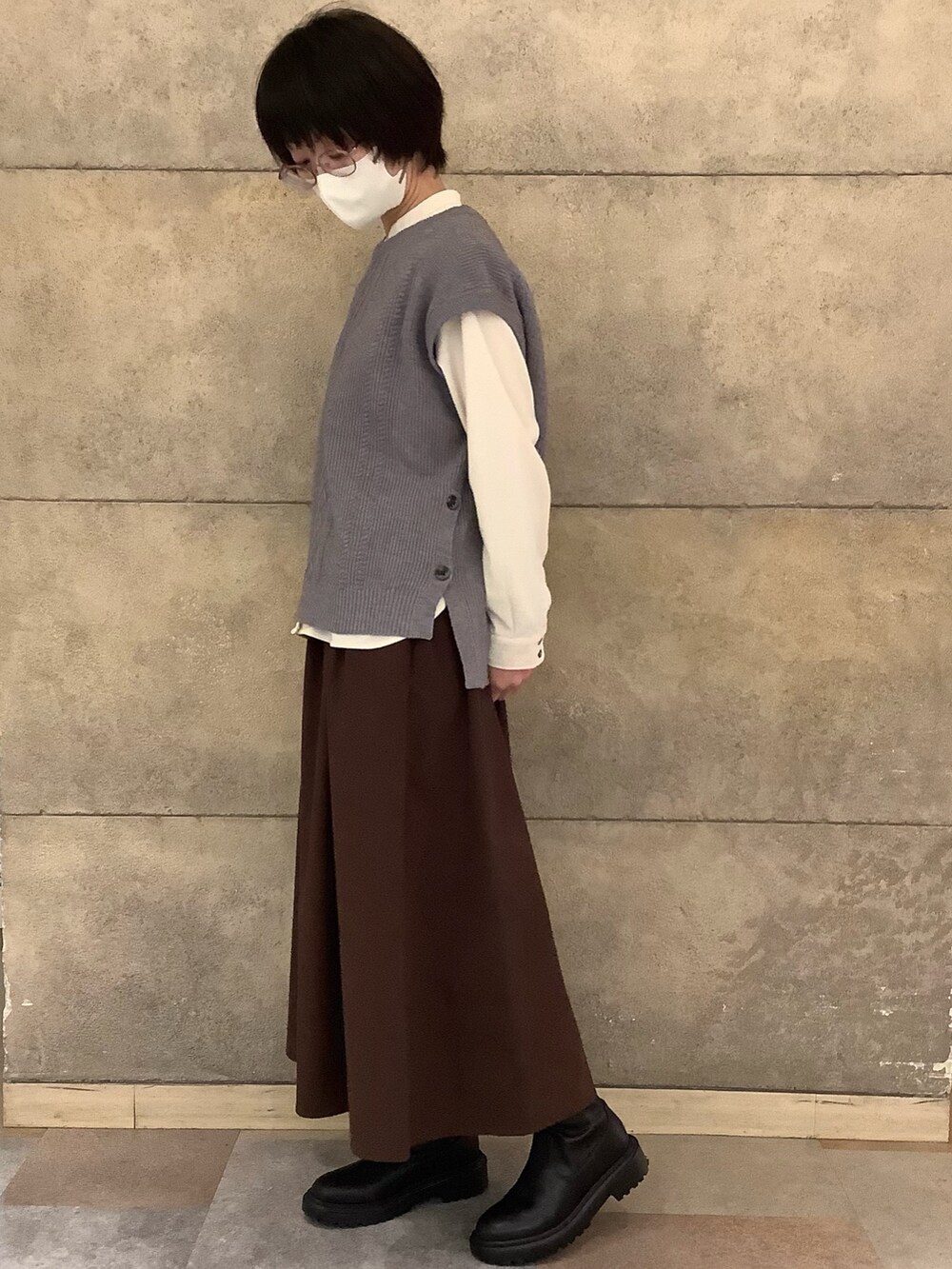 グレー系のベストを着用したレディースの冬コーディネートの3枚目の写真