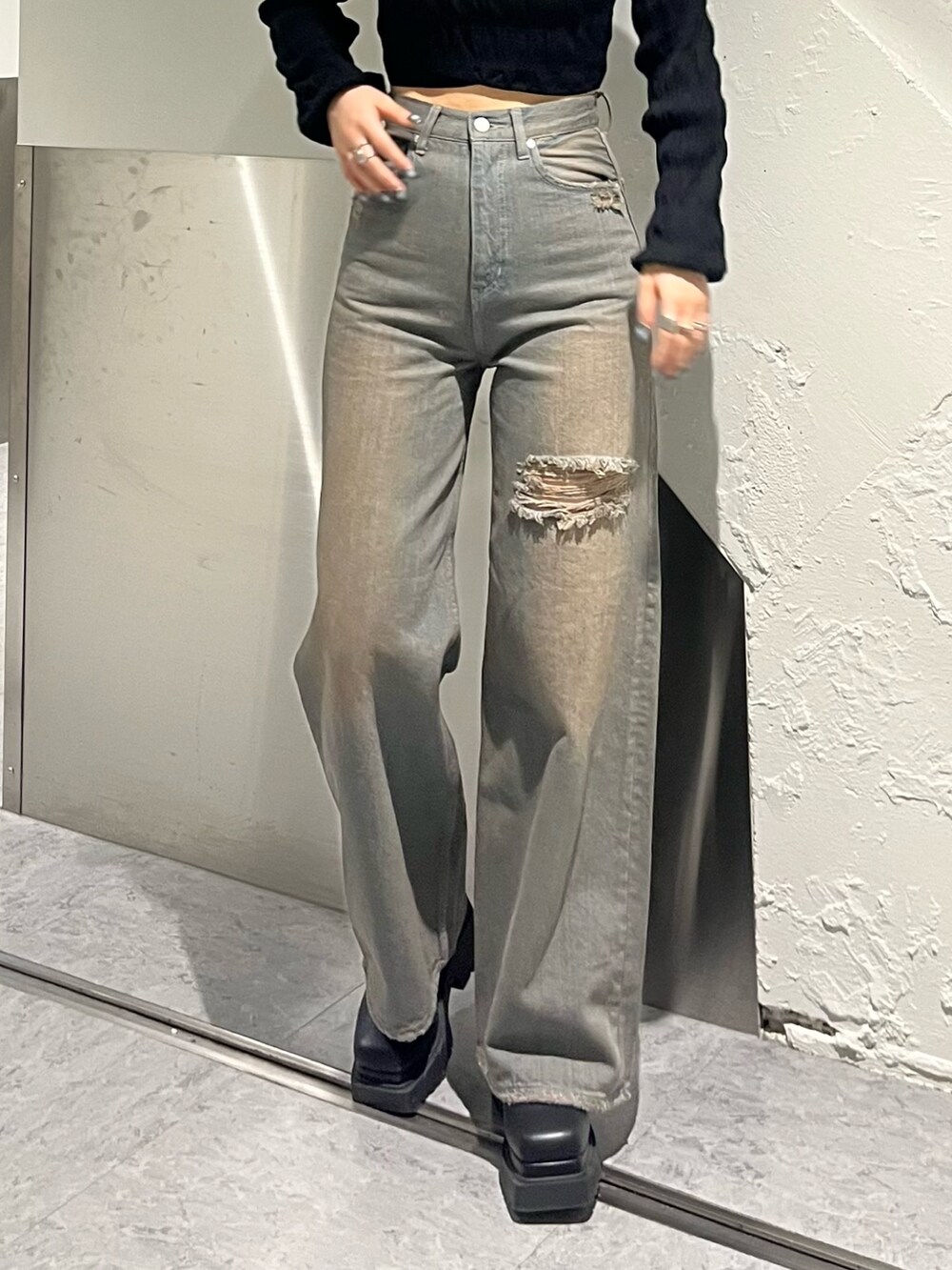 ブラック系のニット/セーター、グレー系のデニムパンツ、ブラック系のブーツを着用したレディースの冬コーディネートの6枚目の写真