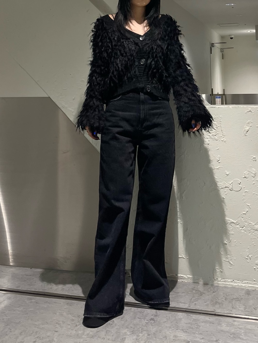 ブラック系のカーディガン/ボレロ、ブラック系のデニムパンツ、ブラック系のブーツを着用したレディースの秋コーディネートの2枚目の写真