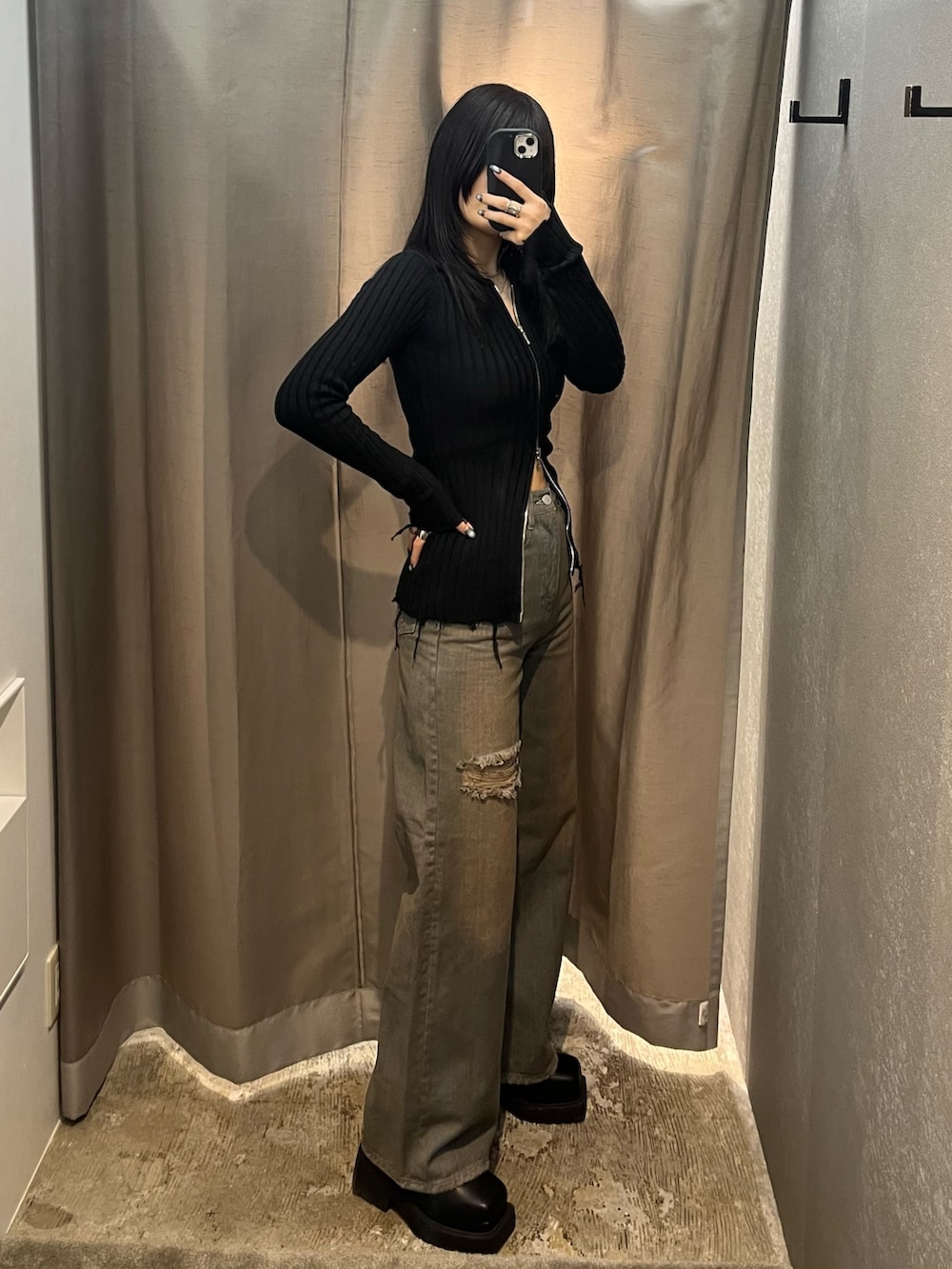 ブラック系のニット/セーター、グレー系のデニムパンツ、ブラック系のブーツを着用したレディースの冬コーディネートの2枚目の写真