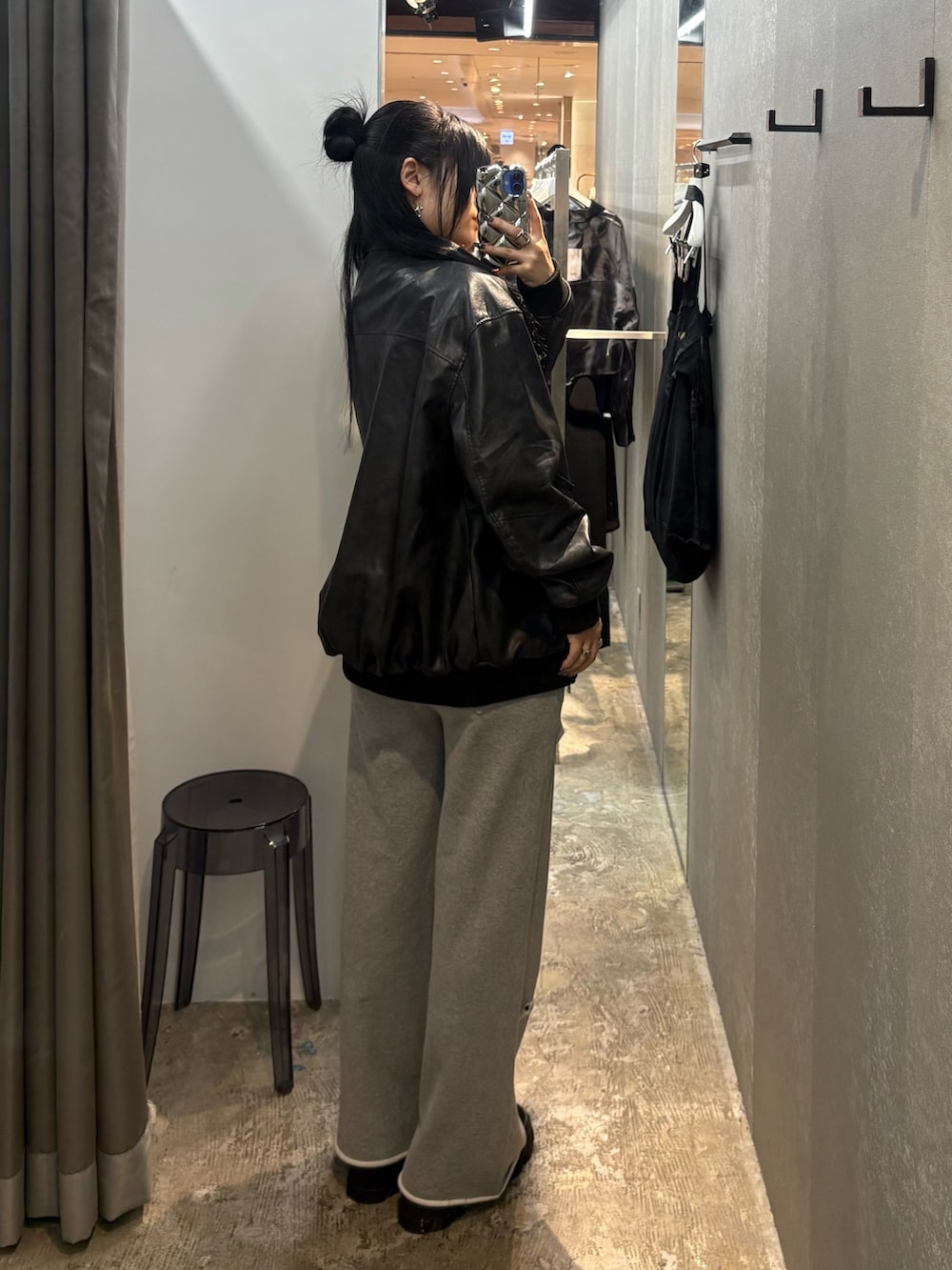 ブラック系のブルゾン、グレー系のスウェットパンツ、ブラック系のブーツを着用したレディースの秋コーディネートの3枚目の写真