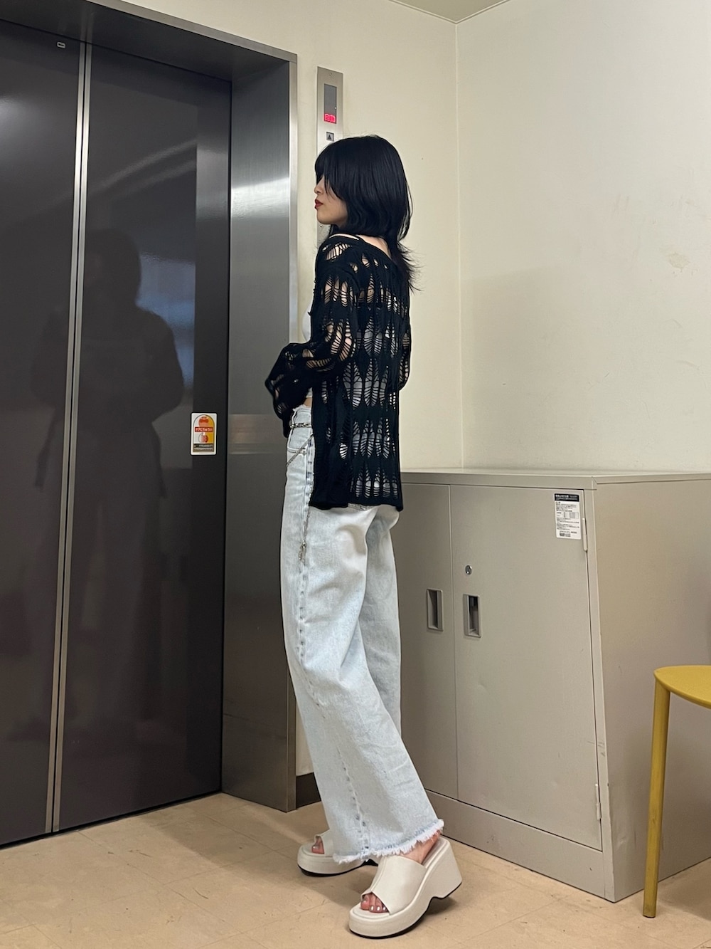 ホワイト系のキャミソール、ブルー系のデニムパンツ、ブラック系のカーディガン/ボレロを着用したレディースの春コーディネートの2枚目の写真