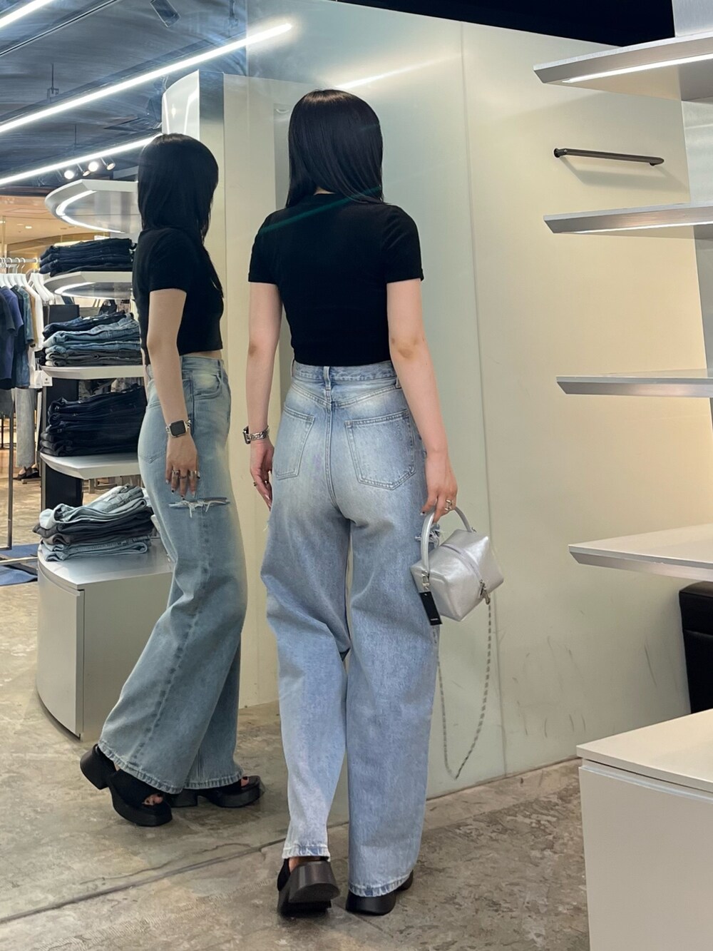 ブラック系のTシャツ/カットソー、ブルー系のデニムパンツ、シルバー系のハンドバッグを着用したレディースの夏コーディネートの3枚目の写真