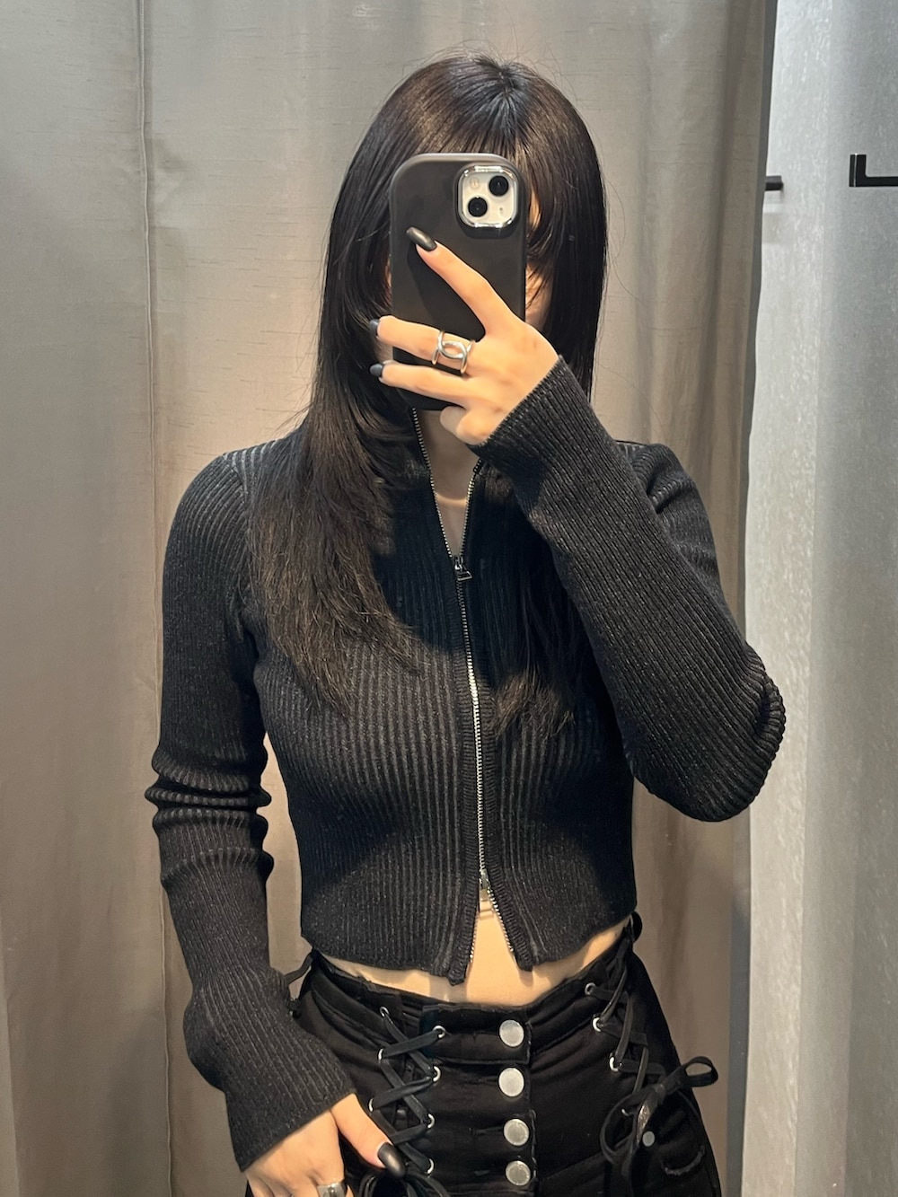 ブラック系のニット/セーター、ブラック系のデニムパンツ、ブラック系のブーツを着用したレディースの冬コーディネートの4枚目の写真