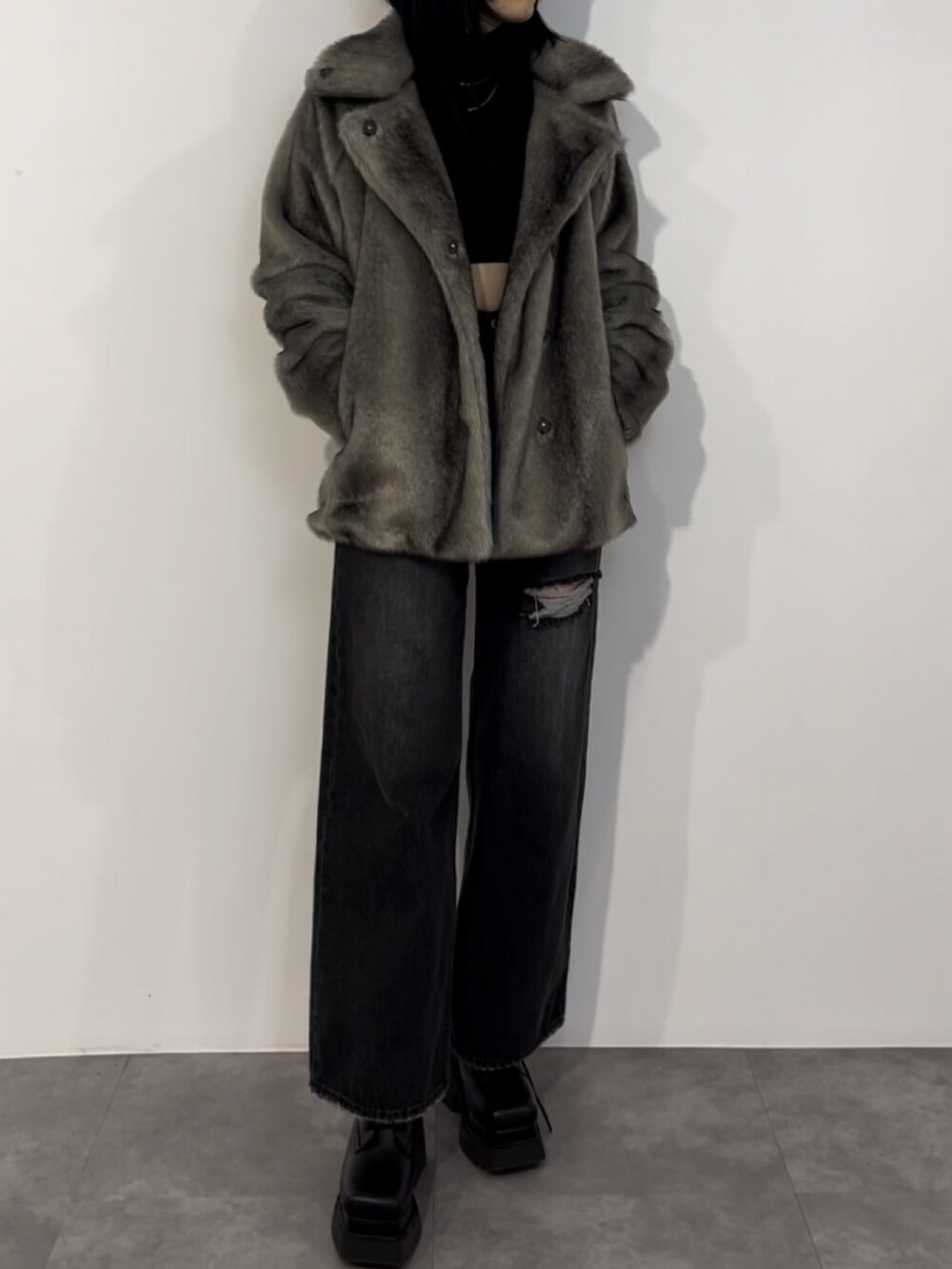 ブラック系のニット/セーター、グレー系のその他アウター、ブラック系のデニムパンツを着用したレディースの冬コーディネートの2枚目の写真