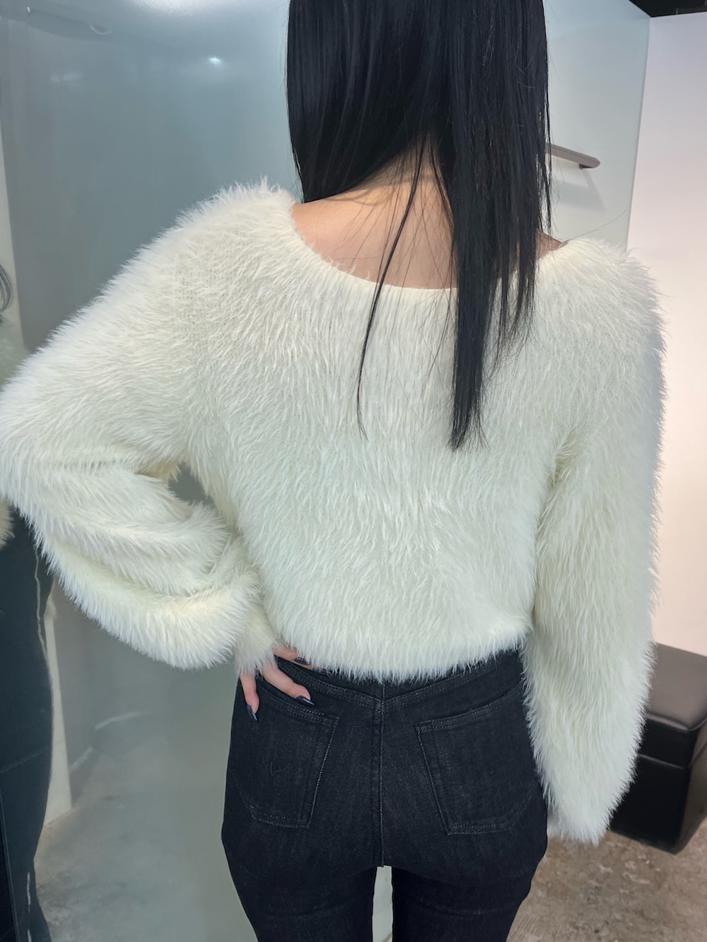 ホワイト系のニット/セーター、ブラック系のデニムパンツ、ブラック系のブーツを着用したレディースの秋コーディネートの5枚目の写真
