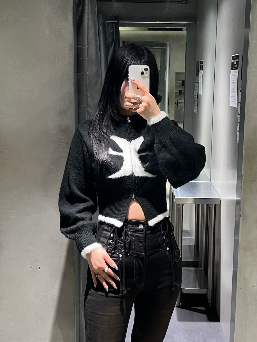 ブラック系のニット/セーター、ブラック系のデニムパンツ、ブラック系のブーツを着用したレディースの冬コーディネートの4枚目の写真