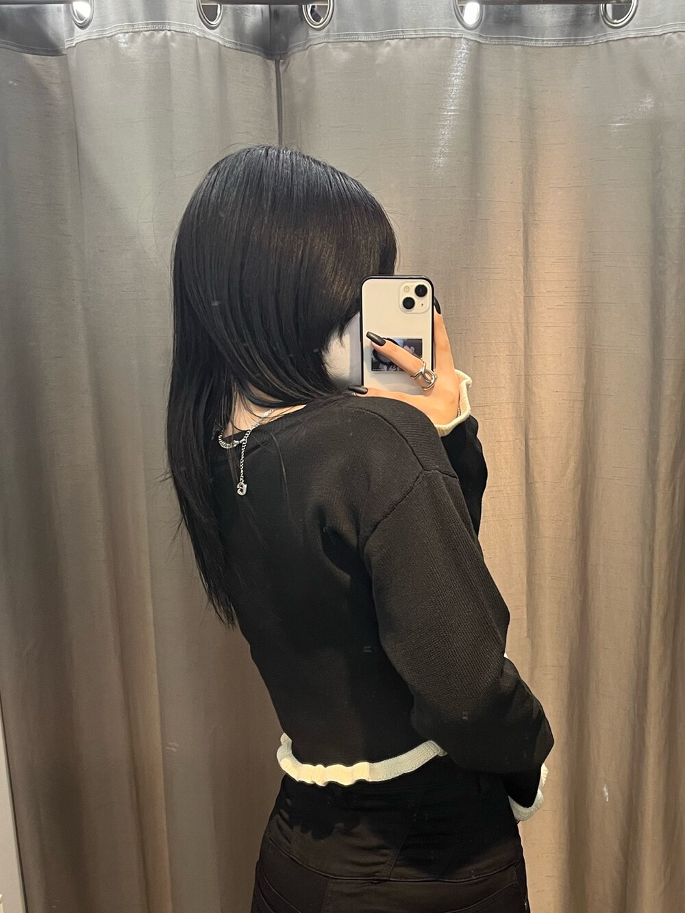 ブラック系のニット/セーター、ブラック系のデニムパンツ、ブラック系のブーツを着用したレディースの冬コーディネートの5枚目の写真