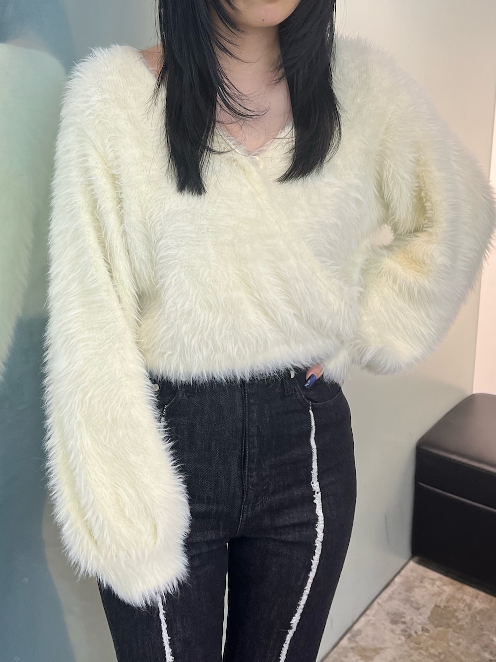 ホワイト系のニット/セーター、ブラック系のデニムパンツ、ブラック系のブーツを着用したレディースの秋コーディネートの4枚目の写真