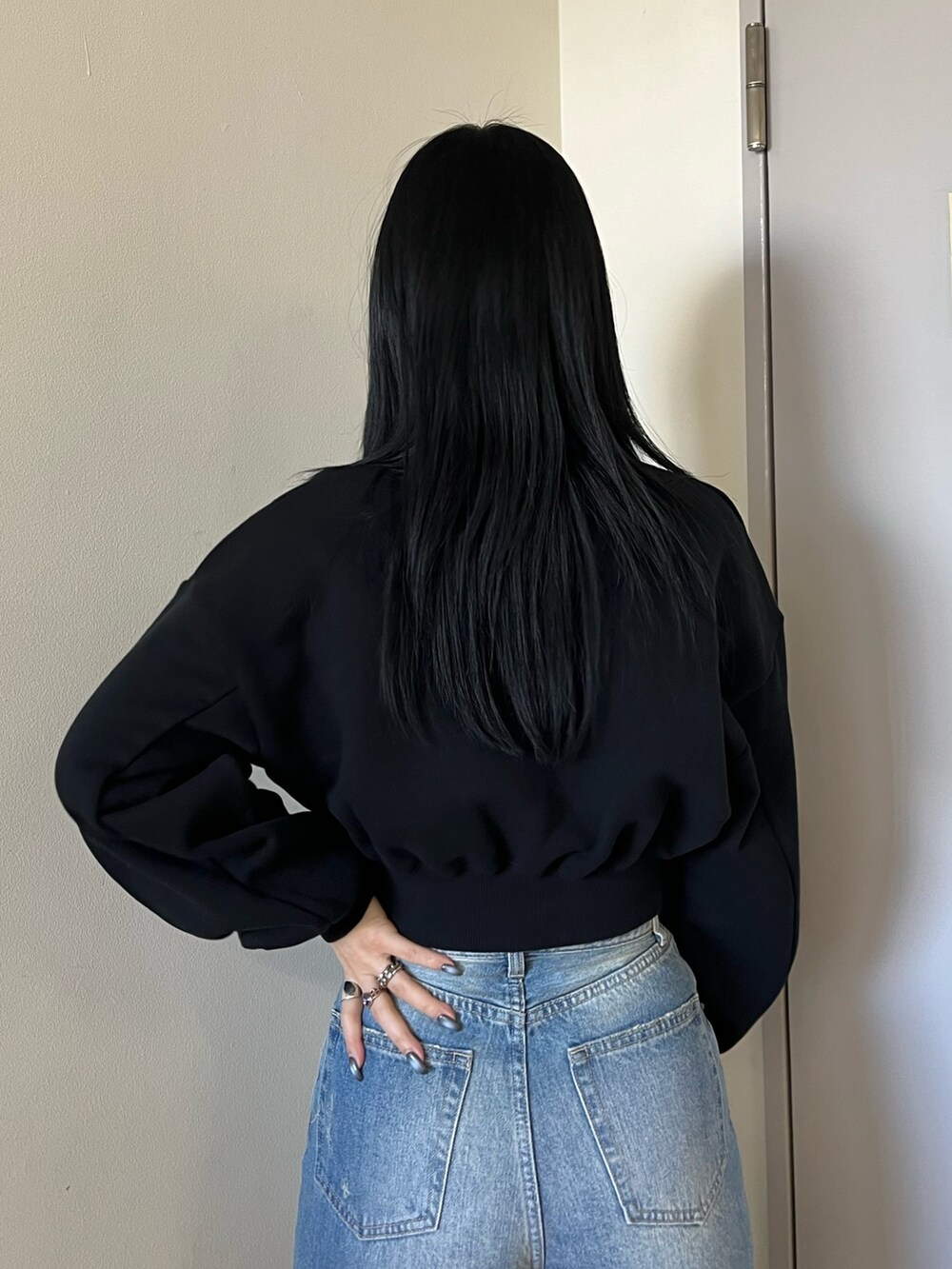 ブラック系のスウェット、ブルー系のデニムパンツ、ブラック系のショルダーバッグを着用したレディースの冬コーディネートの6枚目の写真