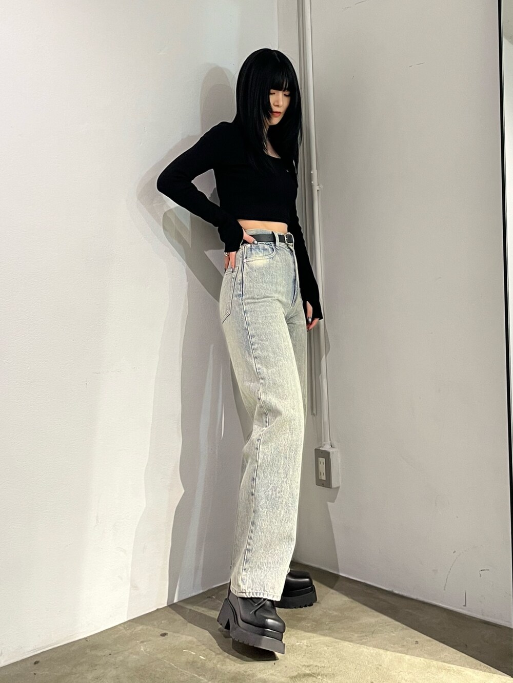 ブラック系のTシャツ/カットソー、ブラック系のブーツ、ブルー系のデニムパンツを着用したレディースの春コーディネートの3枚目の写真