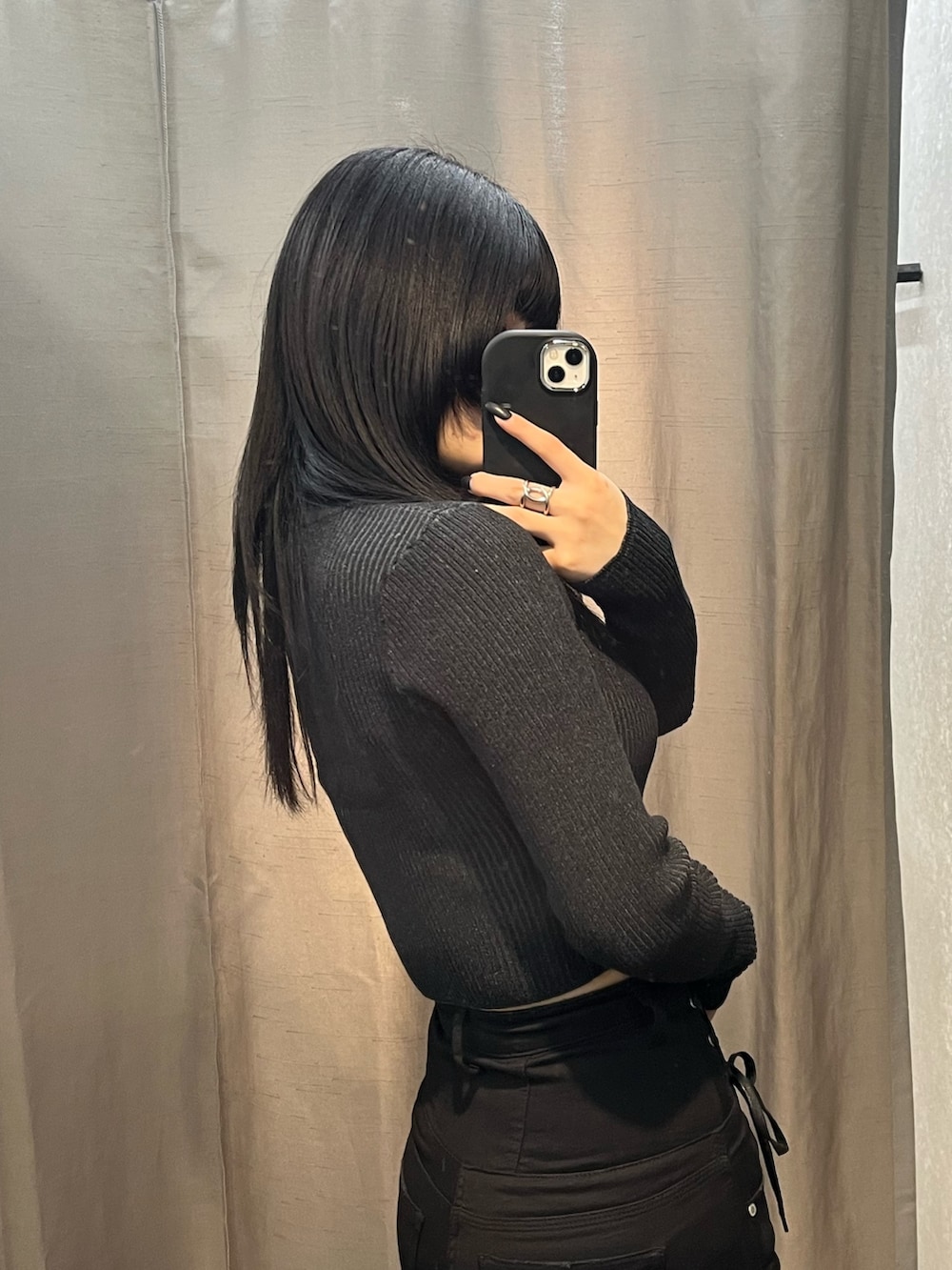 ブラック系のニット/セーター、ブラック系のデニムパンツ、ブラック系のブーツを着用したレディースの冬コーディネートの5枚目の写真