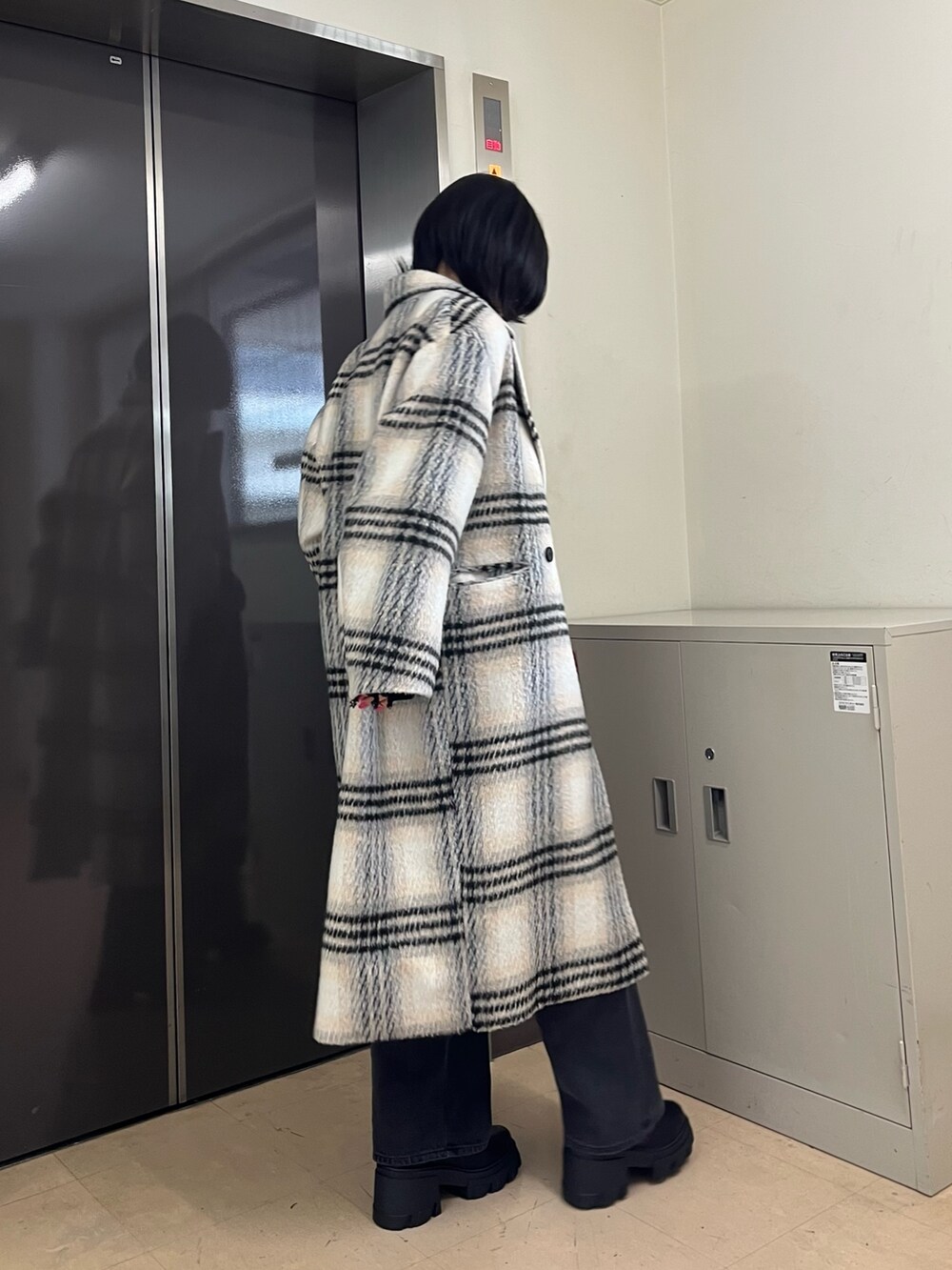 ブラック系のニット/セーター、その他のチェスターコート、グレー系のデニムパンツを着用したレディースの冬コーディネートの3枚目の写真