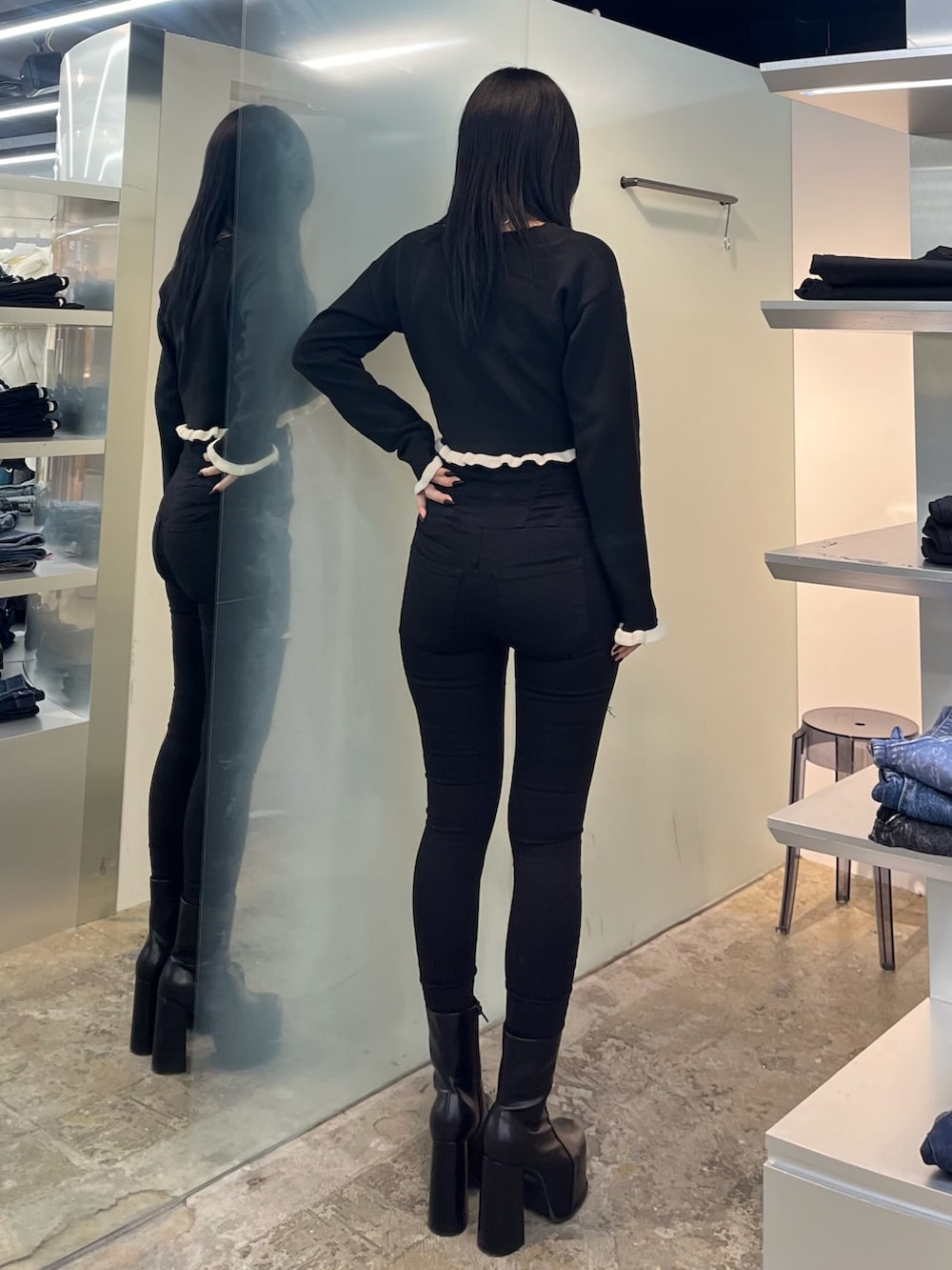 ブラック系のニット/セーター、ブラック系のデニムパンツ、ブラック系のブーツを着用したレディースの冬コーディネートの3枚目の写真