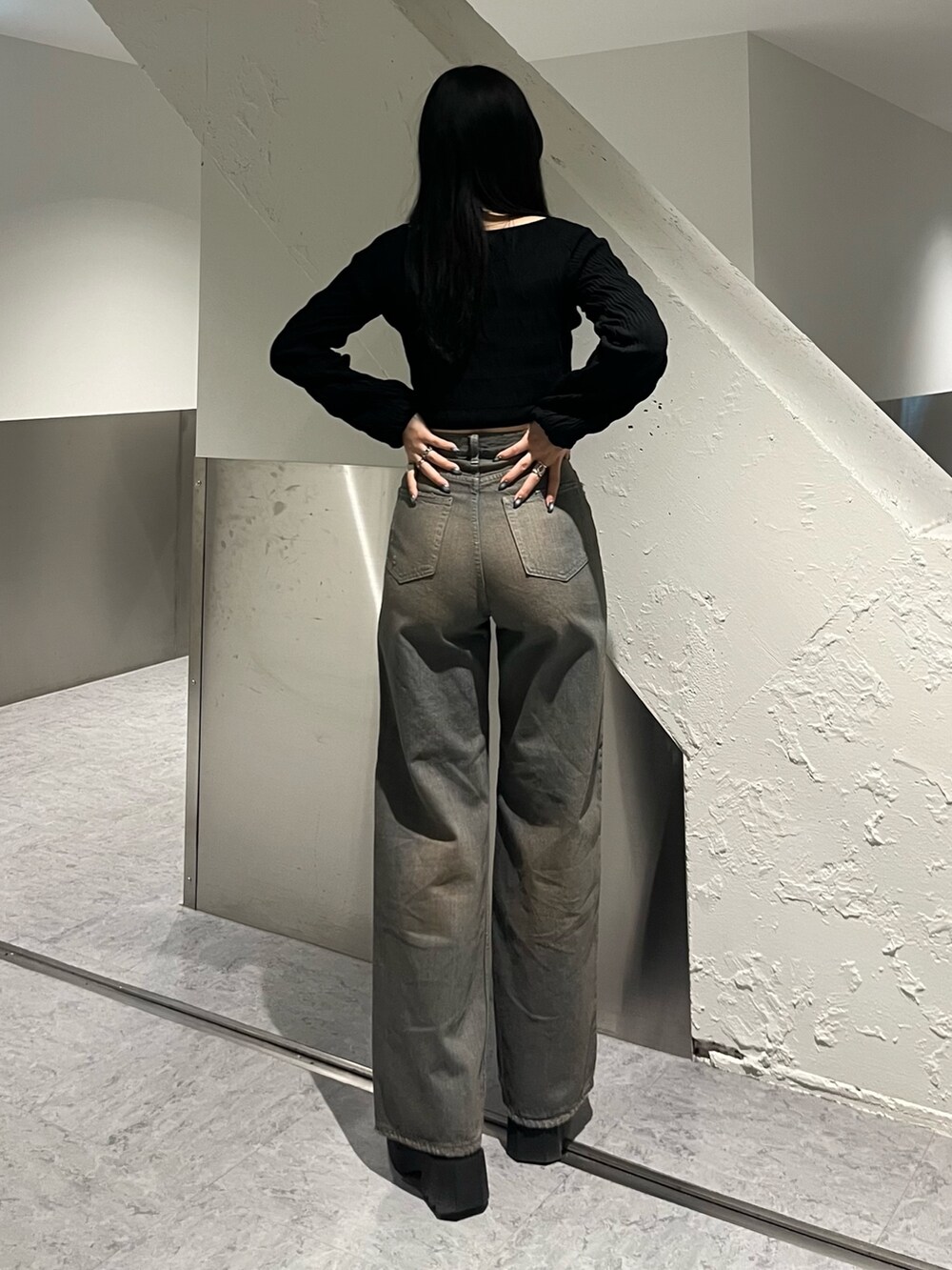 ブラック系のニット/セーター、グレー系のデニムパンツ、ブラック系のブーツを着用したレディースの冬コーディネートの4枚目の写真