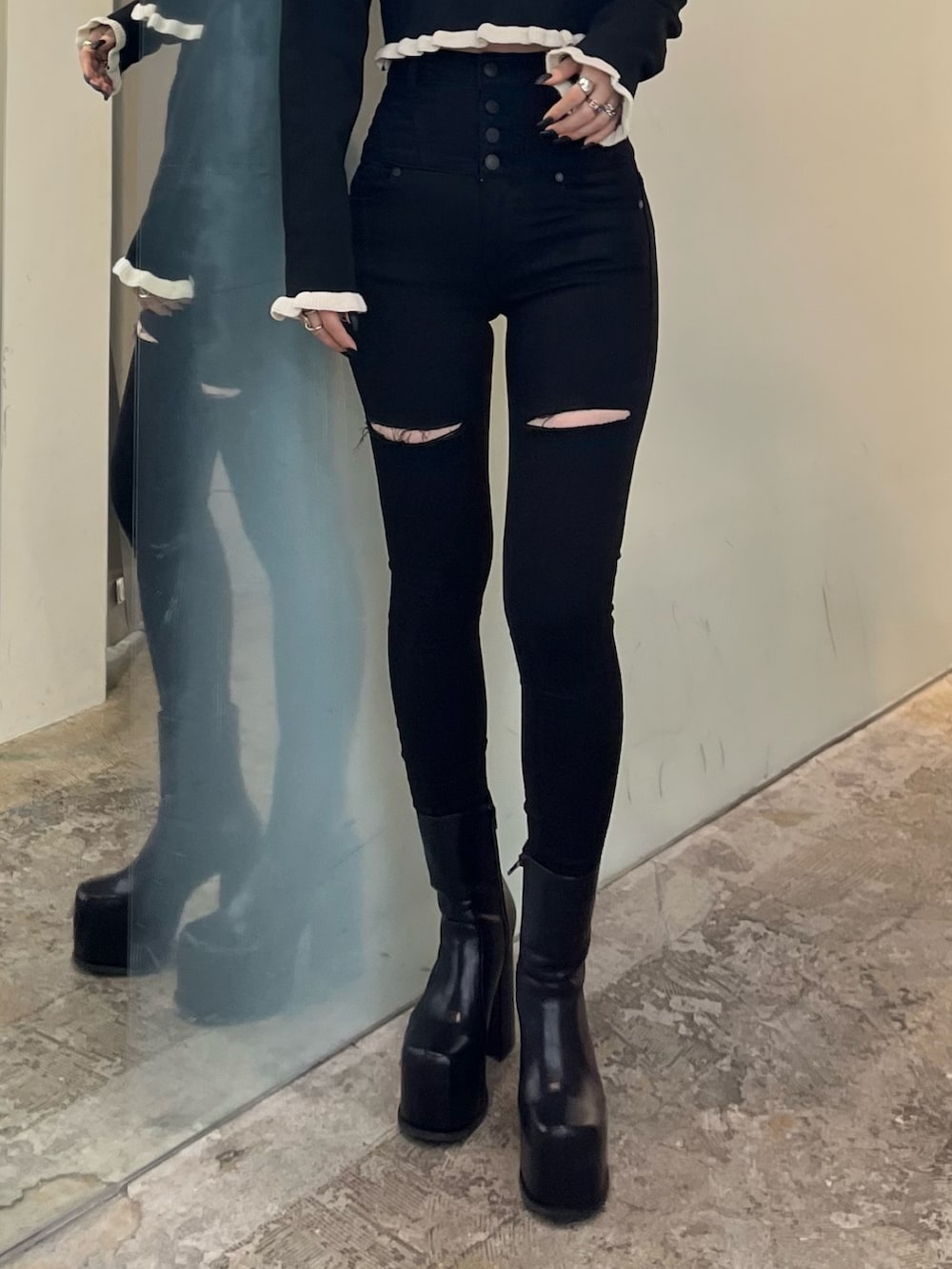 ブラック系のニット/セーター、ブラック系のデニムパンツ、ブラック系のブーツを着用したレディースの冬コーディネートの6枚目の写真