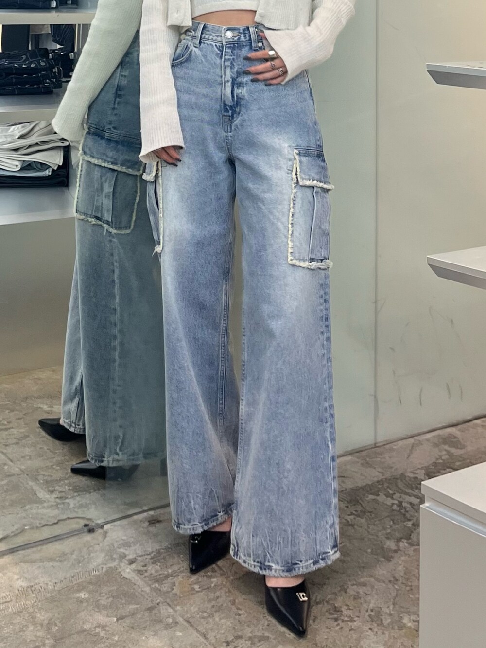 ホワイト系のニット/セーター、ブルー系のデニムパンツ、ブラック系のパンプスを着用したレディースの春コーディネートの6枚目の写真