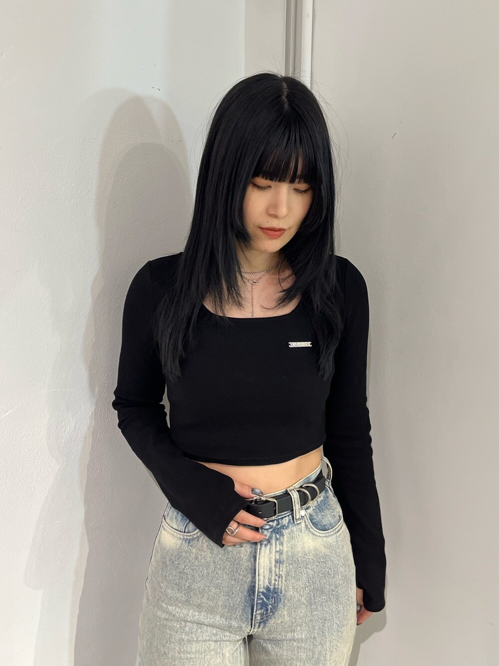 ブラック系のTシャツ/カットソー、ブラック系のブーツ、ブルー系のデニムパンツを着用したレディースの春コーディネートの5枚目の写真