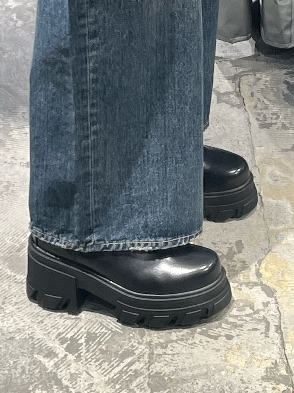 レッド系のニット/セーター、ブルー系のデニムパンツ、ブラック系のブーツを着用したレディースの秋コーディネートの6枚目の写真