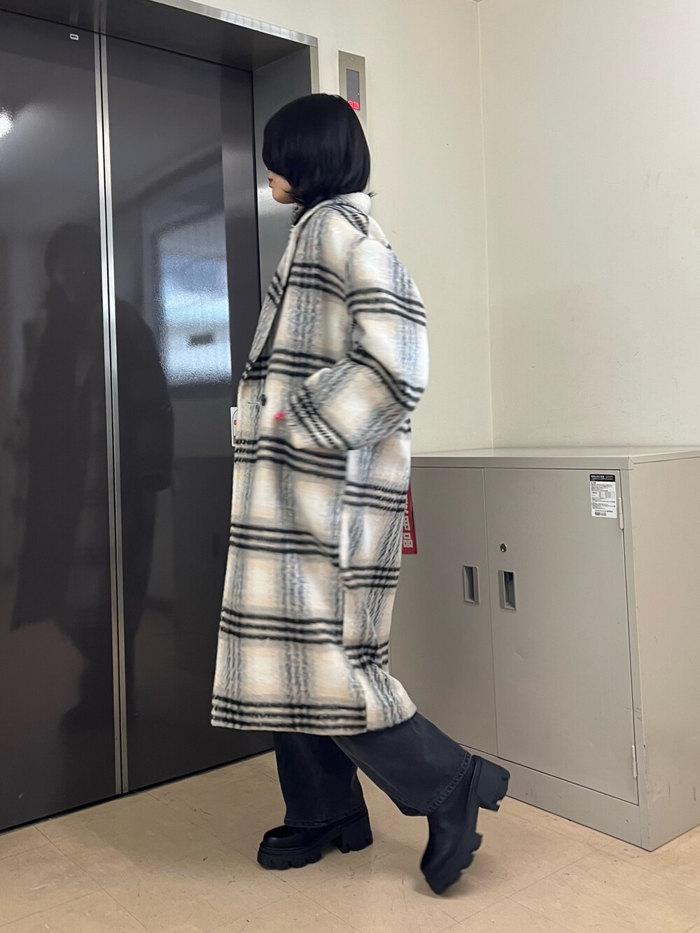 ブラック系のニット/セーター、その他のチェスターコート、グレー系のデニムパンツを着用したレディースの冬コーディネートの2枚目の写真