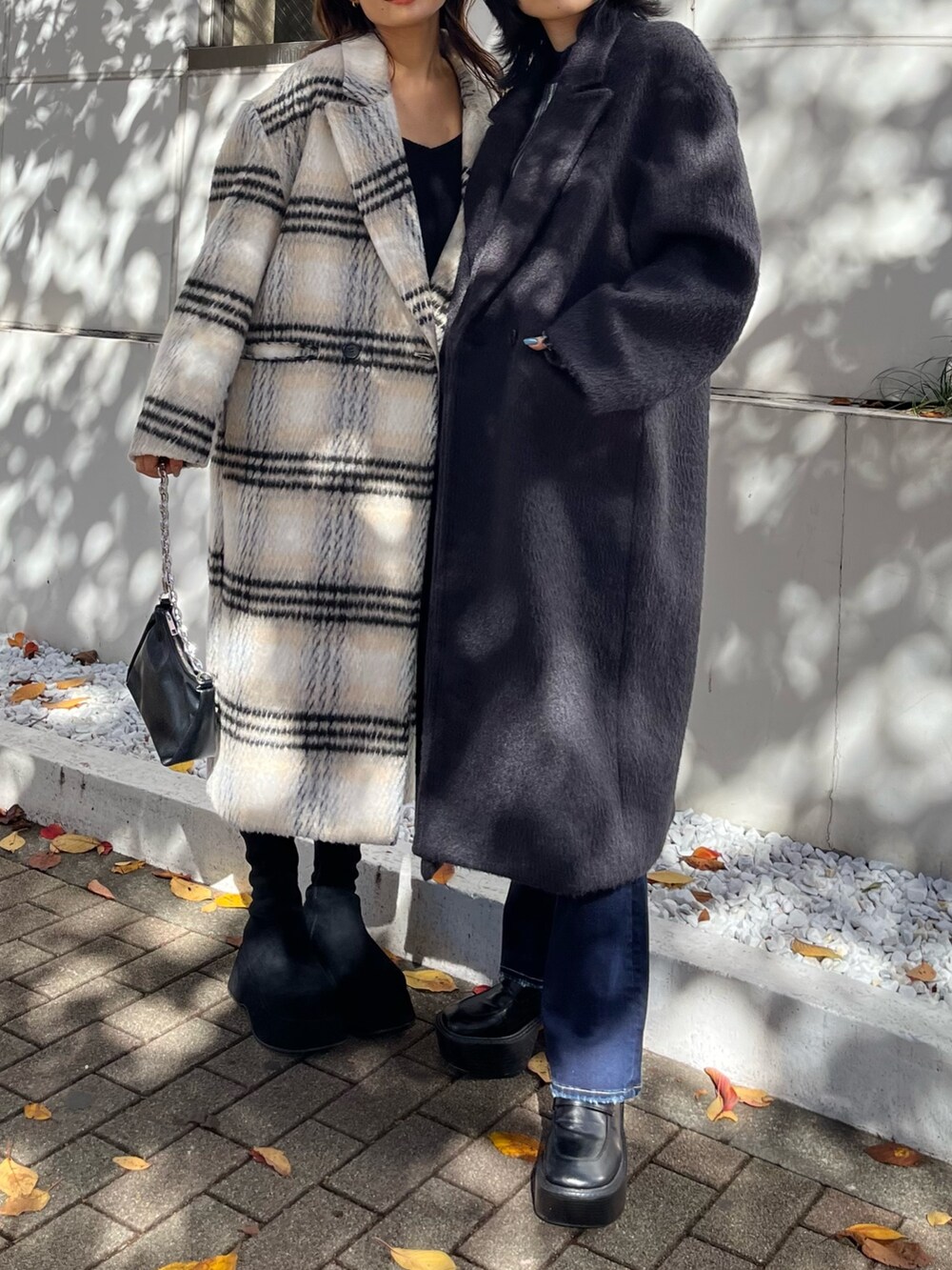 ブラック系のチェスターコート、その他のニット/セーター、ブルー系のデニムパンツを着用したレディースの冬コーディネートの5枚目の写真