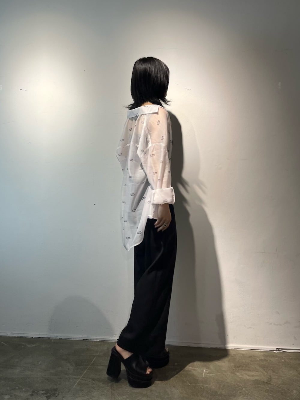 ブラック系のサロペット/オーバーオール、ホワイト系のシャツ/ブラウス、ブラック系のサンダルを着用したレディースの春コーディネートの2枚目の写真