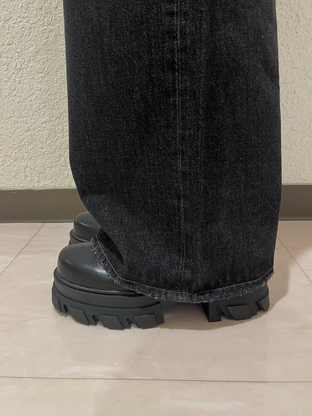 ブルー系のニット/セーター、ブラック系のデニムパンツ、ブラック系のブーツを着用したレディースの夏コーディネートの6枚目の写真