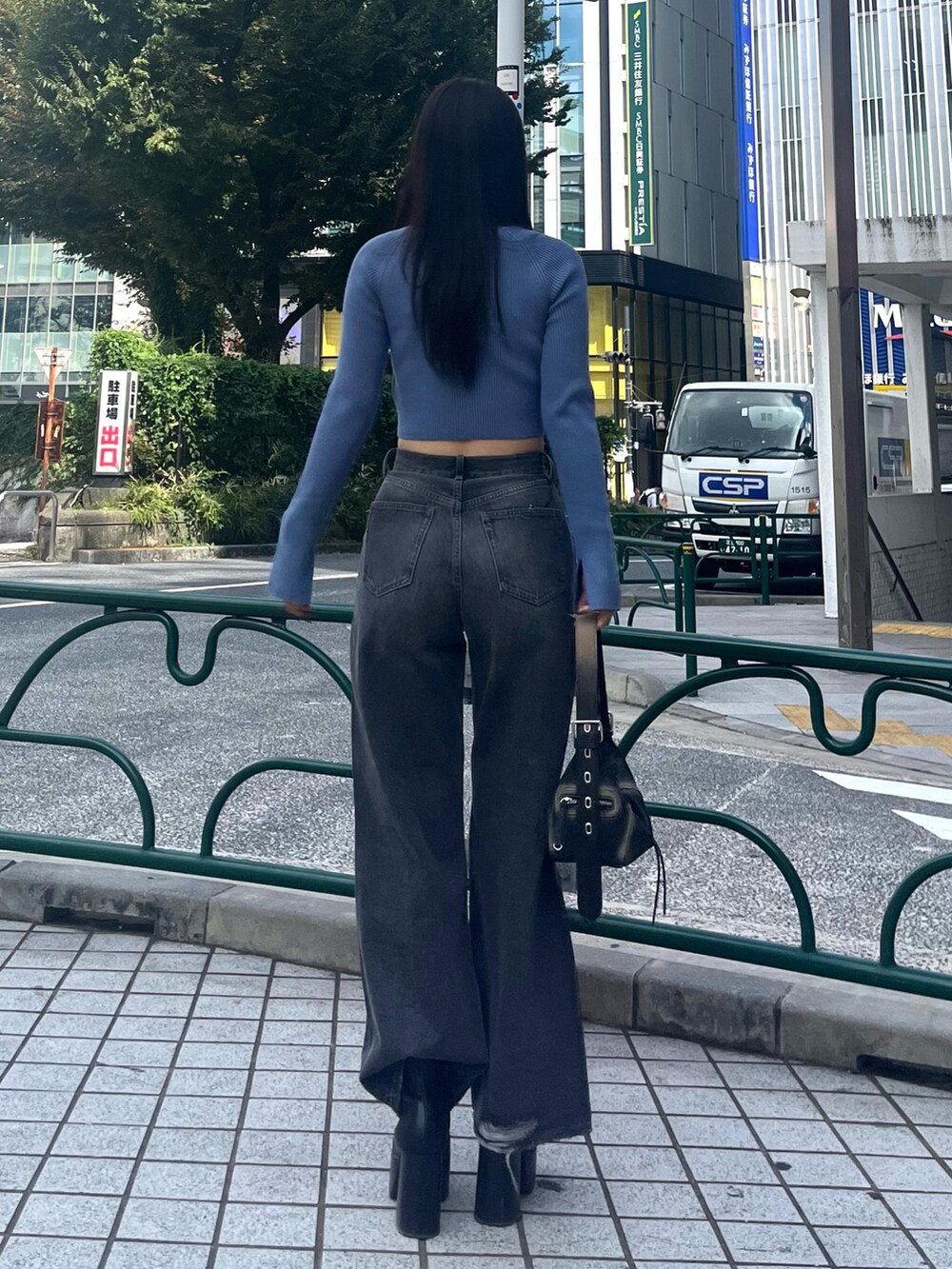 ブルー系のニット/セーター、グレー系のデニムパンツ、ブラック系のブーツを着用したレディースの秋コーディネートの4枚目の写真