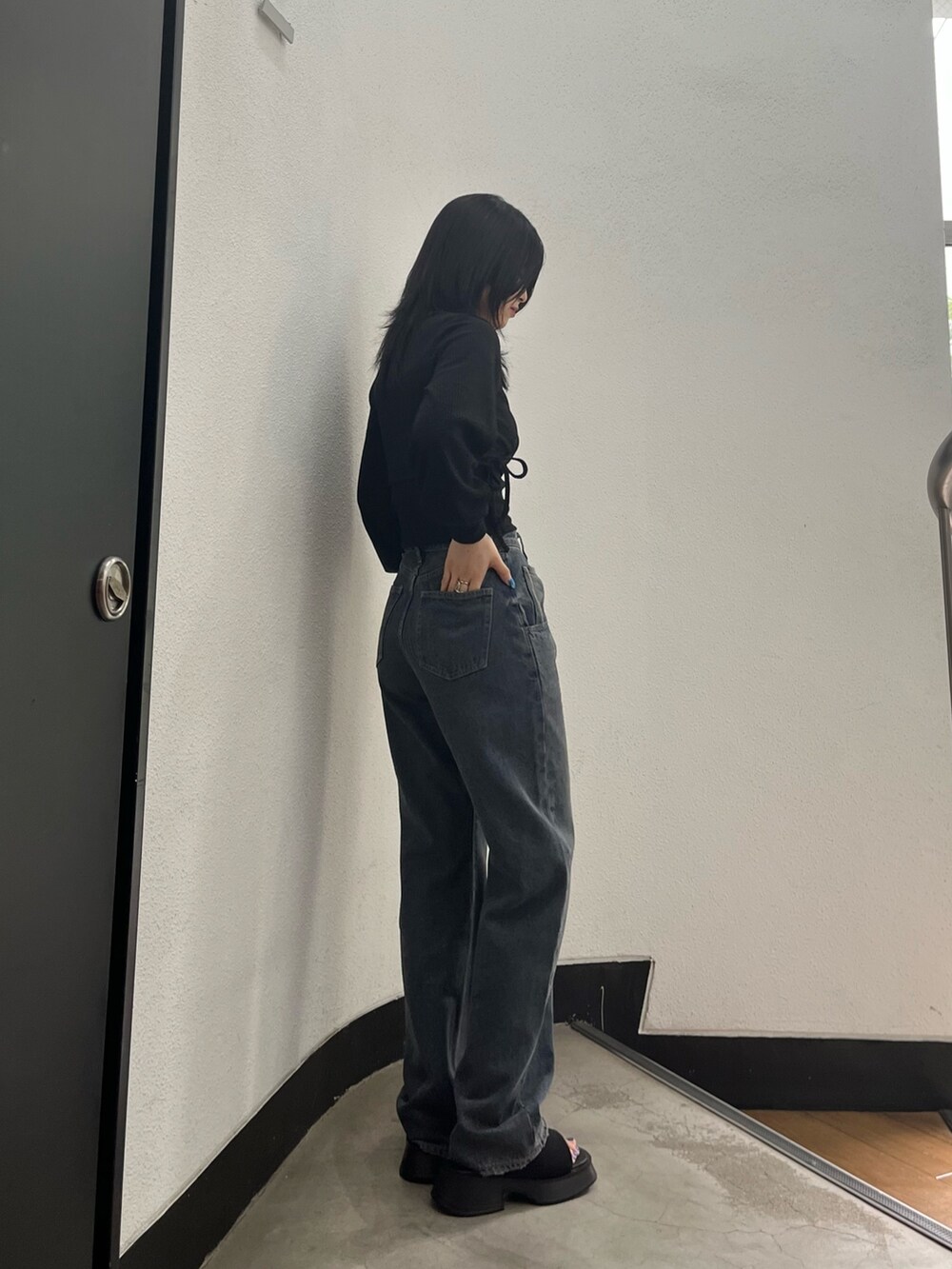 ブルー系のデニムパンツ、ブラック系のサンダル、シルバー系のネックレスを着用したレディースの夏コーディネートの3枚目の写真
