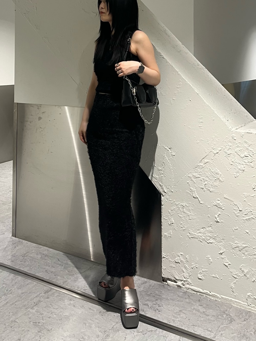 ブラック系のタンクトップ、ブラック系のスカート、ブラック系のショルダーバッグを着用したレディースの春コーディネートの2枚目の写真