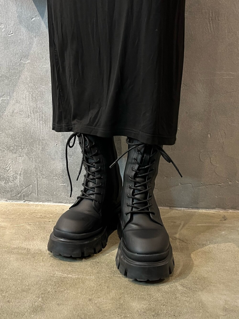 ブラック系のブーツ、パープル系のハンドバッグ、ブラック系のワンピースを着用したレディースの春コーディネートの4枚目の写真