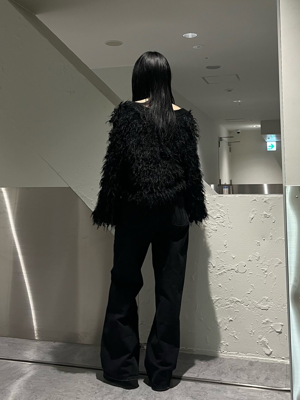 ブラック系のカーディガン/ボレロ、ブラック系のデニムパンツ、ブラック系のブーツを着用したレディースの秋コーディネートの4枚目の写真