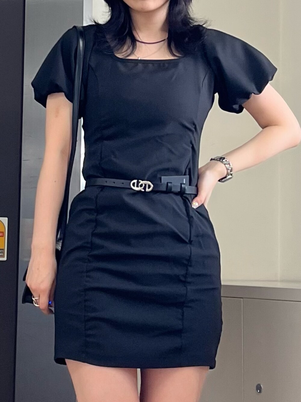 ブラック系のワンピース、ブラック系のショルダーバッグ、ブラック系のブーツを着用したレディースの春コーディネートの2枚目の写真