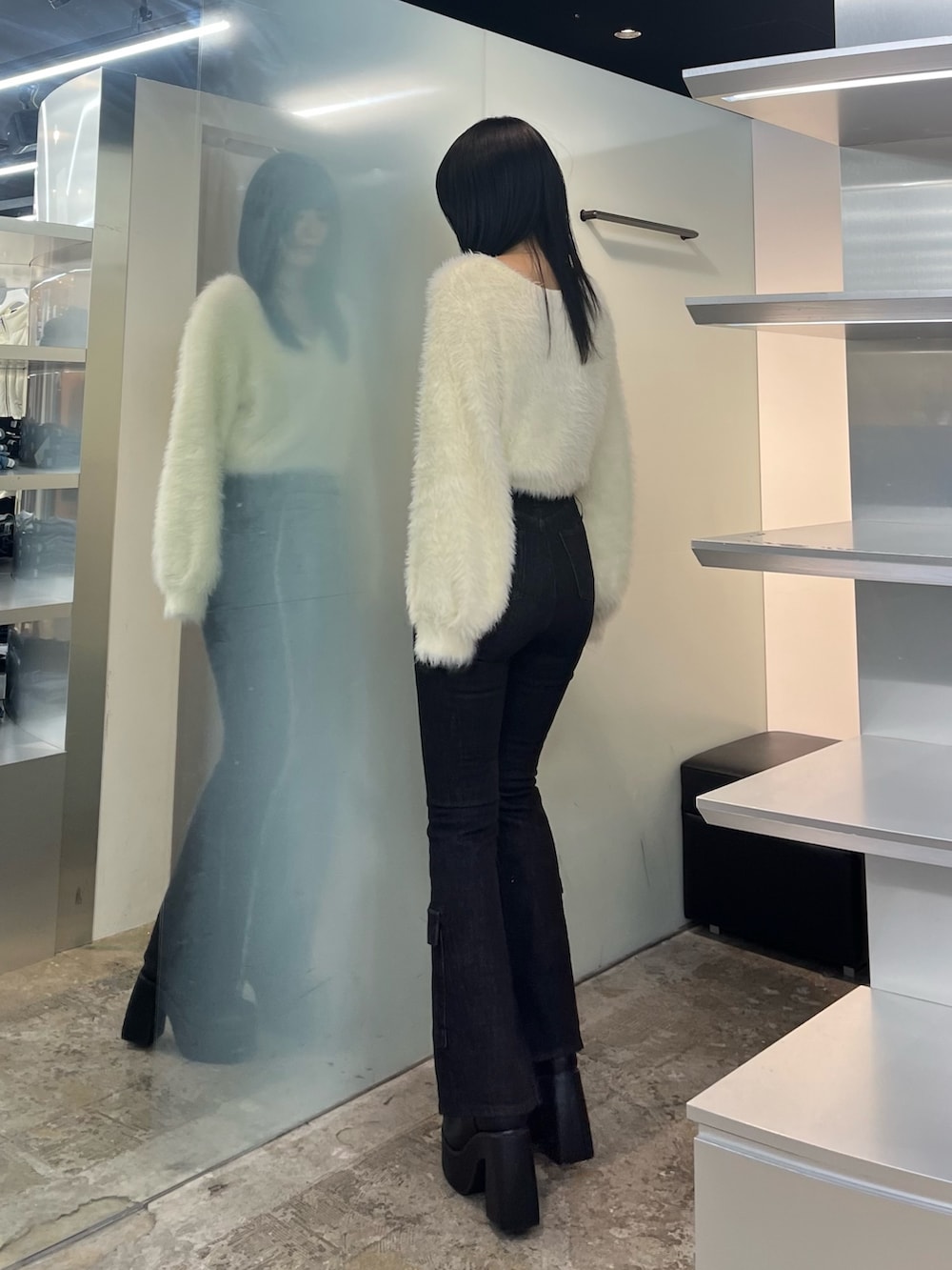 ホワイト系のニット/セーター、ブラック系のデニムパンツ、ブラック系のブーツを着用したレディースの秋コーディネートの3枚目の写真
