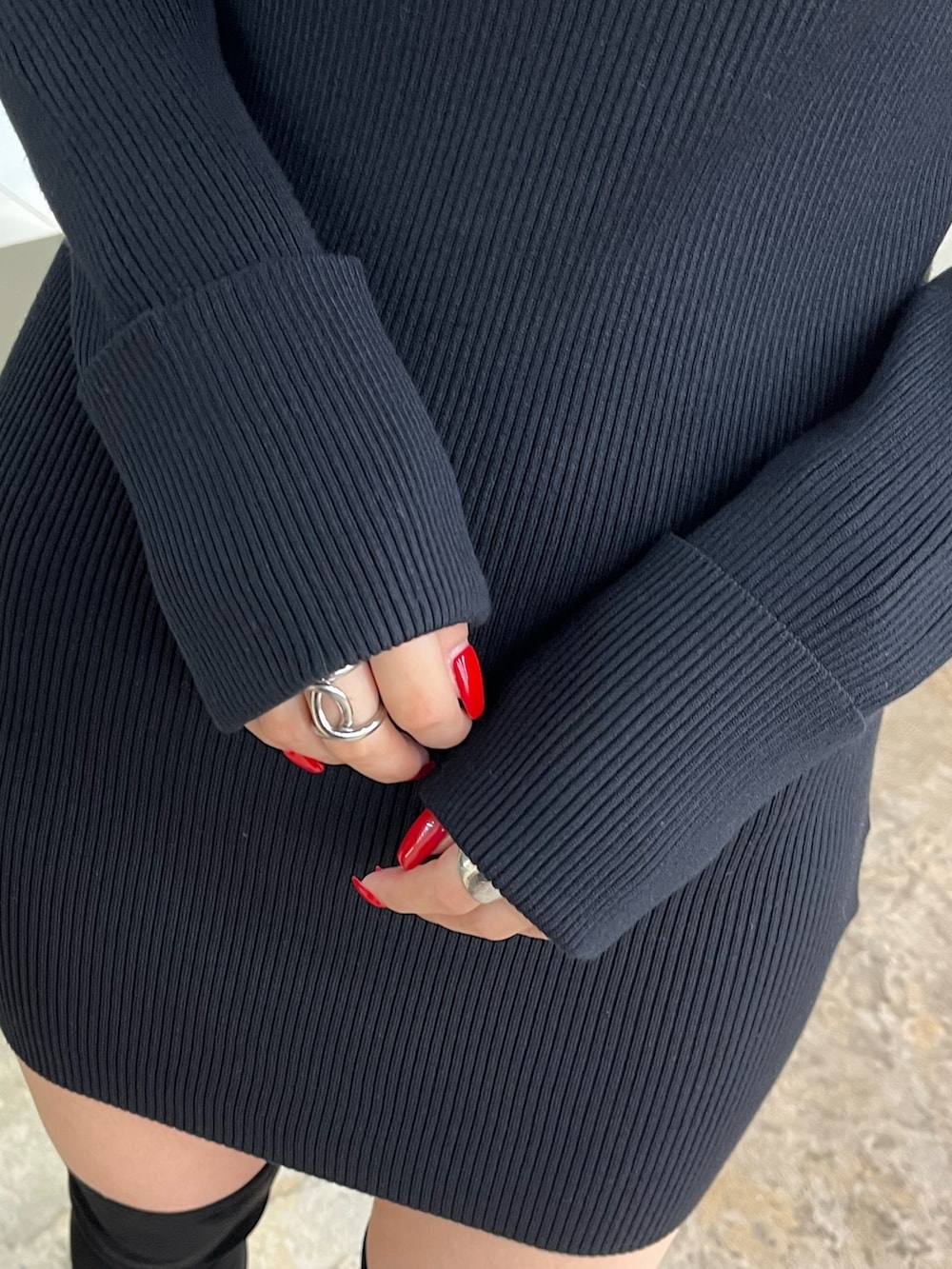 ブラック系のワンピース、ベージュ系のハンドバッグ、ブラック系のブーツを着用したレディースの秋コーディネートの6枚目の写真