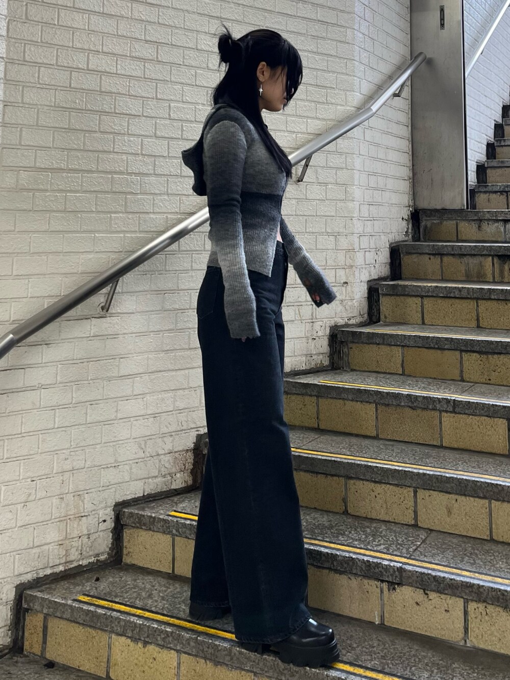 ブラック系のニット/セーター、ブラック系のデニムパンツ、ブラック系のブーツを着用したレディースの冬コーディネートの2枚目の写真