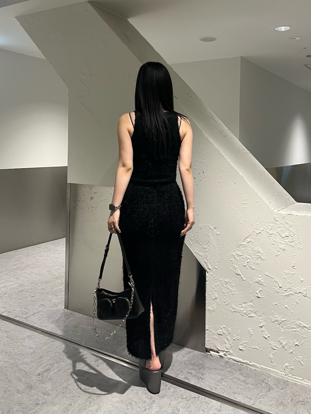 ブラック系のタンクトップ、ブラック系のスカート、ブラック系のショルダーバッグを着用したレディースの春コーディネートの4枚目の写真