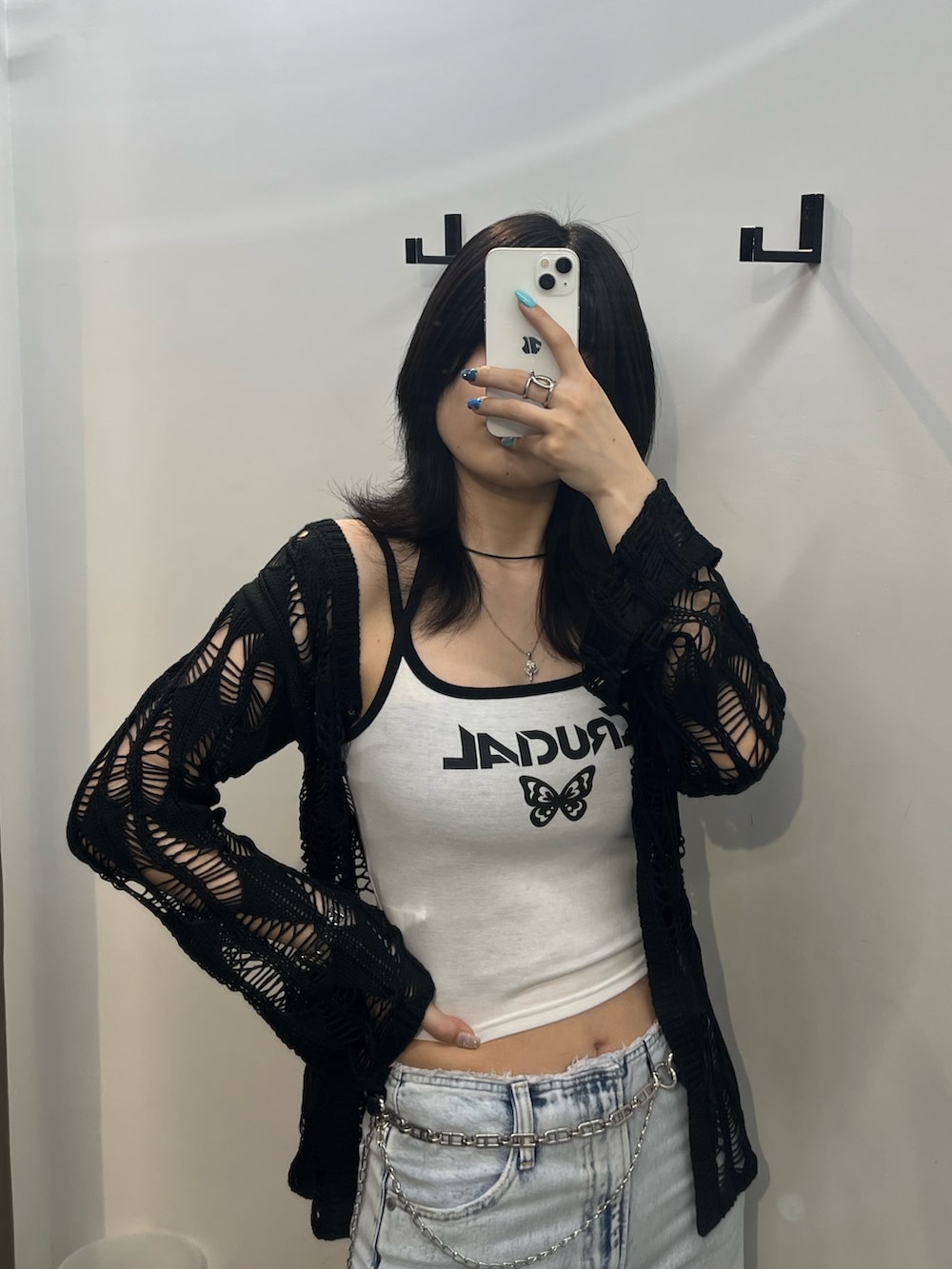 ホワイト系のキャミソール、ブルー系のデニムパンツ、ブラック系のカーディガン/ボレロを着用したレディースの春コーディネートの3枚目の写真