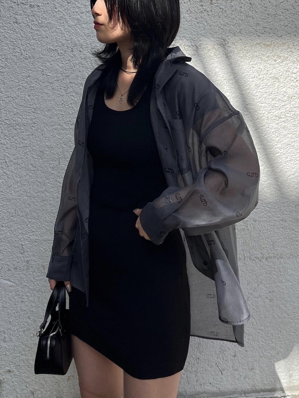 ブラック系のワンピース、ブラック系のハンドバッグ、ブラック系のシャツ/ブラウスを着用したレディースの春コーディネートの3枚目の写真