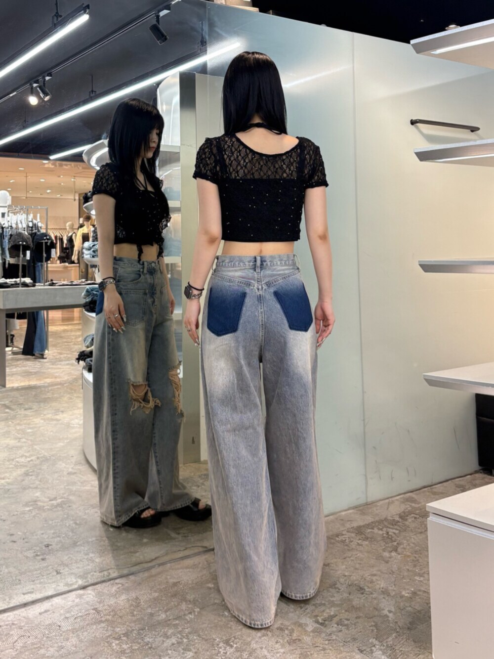 ブルー系のデニムパンツ、ブラック系のTシャツ/カットソー、ブラック系のサンダルを着用したレディースの夏コーディネートの3枚目の写真