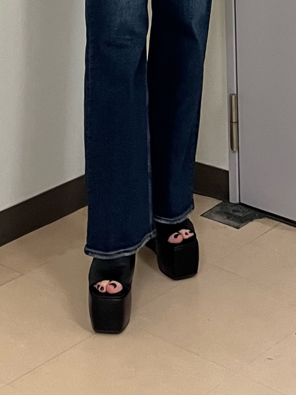 ホワイト系のTシャツ/カットソー、ブルー系のデニムパンツ、ブラック系のサンダルを着用したレディースの春コーディネートの7枚目の写真