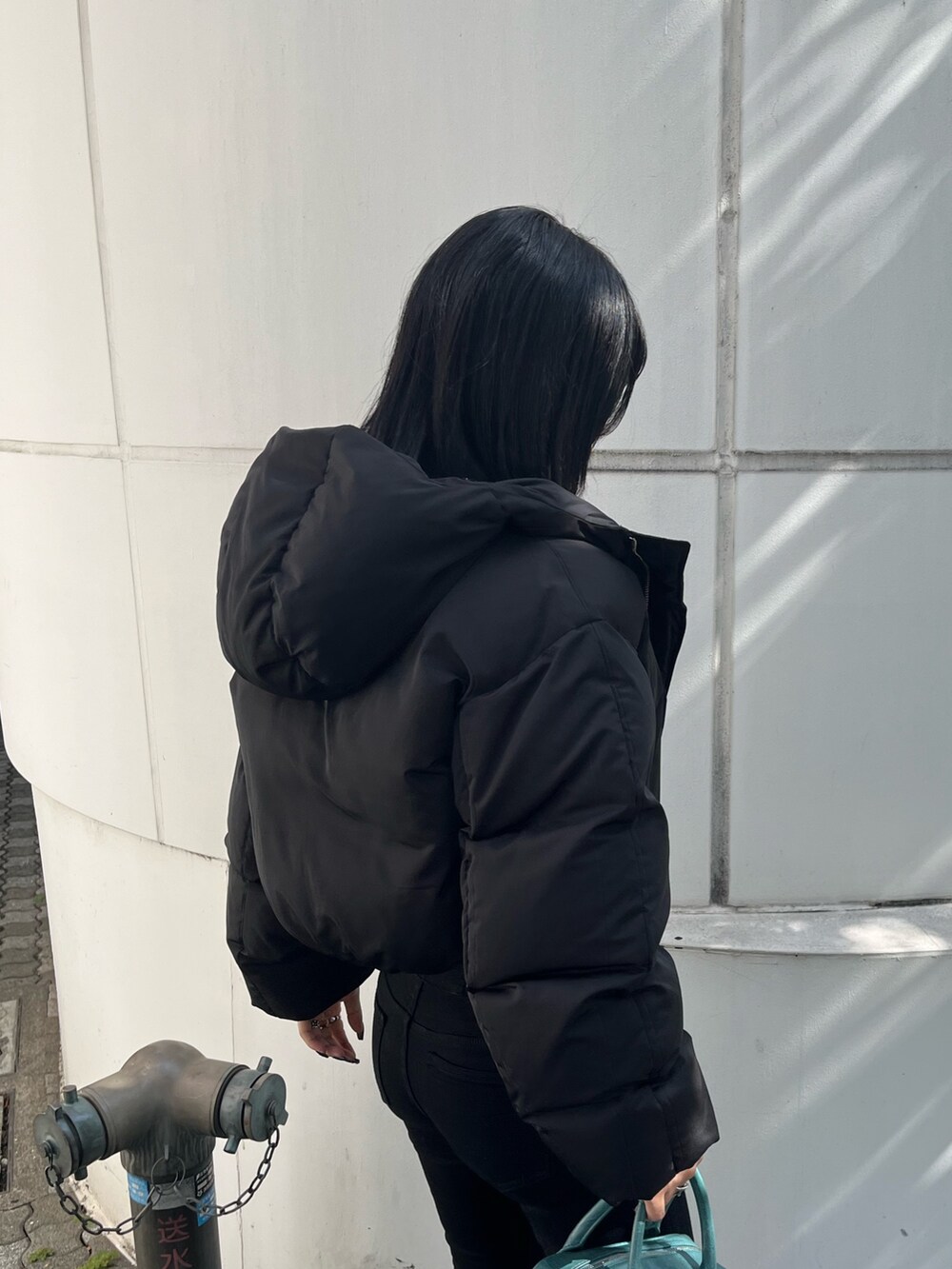 ブラック系のダウンジャケット/コート、その他のニット/セーター、ブラック系のデニムパンツを着用したレディースの秋コーディネートの5枚目の写真