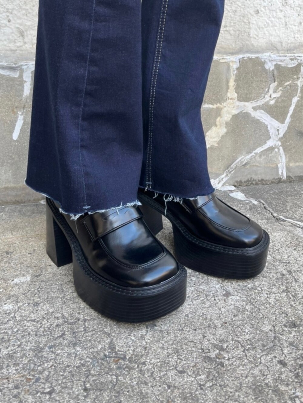 ブラック系のニット/セーター、ブルー系のデニムパンツ、ブラック系のローファーを着用したレディースの秋コーディネートの10枚目の写真
