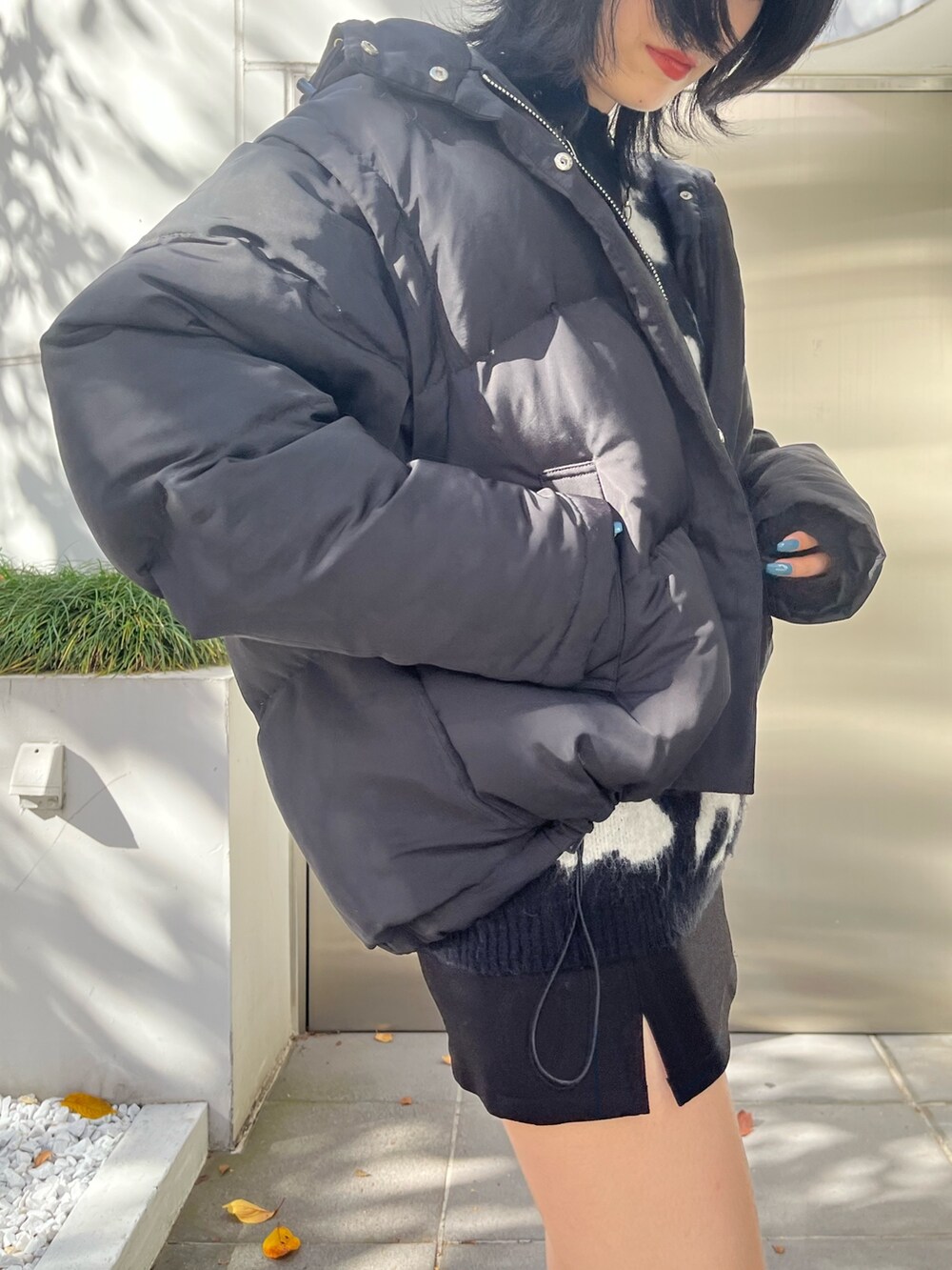 ブラック系のダウンジャケット/コート、ブラック系のニット/セーター、ブラック系のスカートを着用したレディースの冬コーディネートの5枚目の写真