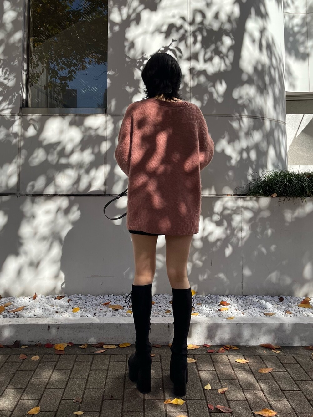 ピンク系のニット/セーター、ブラック系のスカート、ブラック系のハンドバッグを着用したレディースの冬コーディネートの3枚目の写真