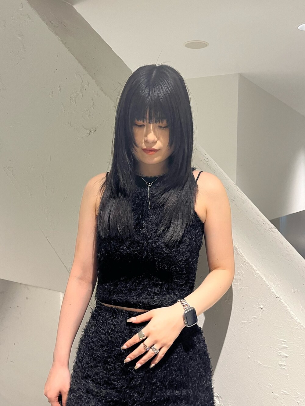 ブラック系のタンクトップ、ブラック系のスカート、ブラック系のショルダーバッグを着用したレディースの春コーディネートの5枚目の写真