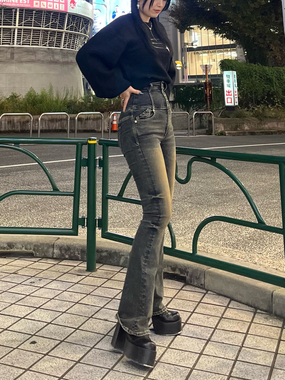 ブラック系のニット/セーター、ブルー系のデニムパンツ、ブラック系のブーツを着用したレディースの秋コーディネートの3枚目の写真