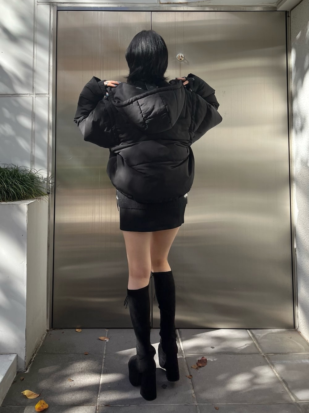 ブラック系のダウンジャケット/コート、ブラック系のニット/セーター、ブラック系のスカートを着用したレディースの冬コーディネートの3枚目の写真