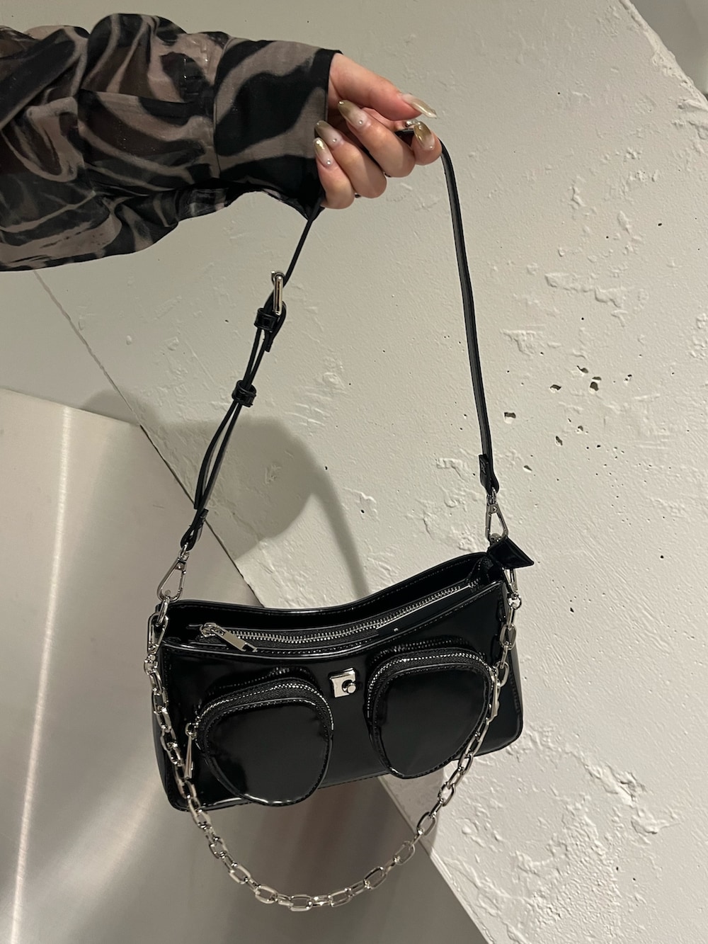 ブラック系のタンクトップ、ブラック系のスカート、ブラック系のショルダーバッグを着用したレディースの春コーディネートの8枚目の写真